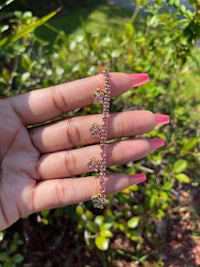 a person holding a pink ring with a pink flower on it